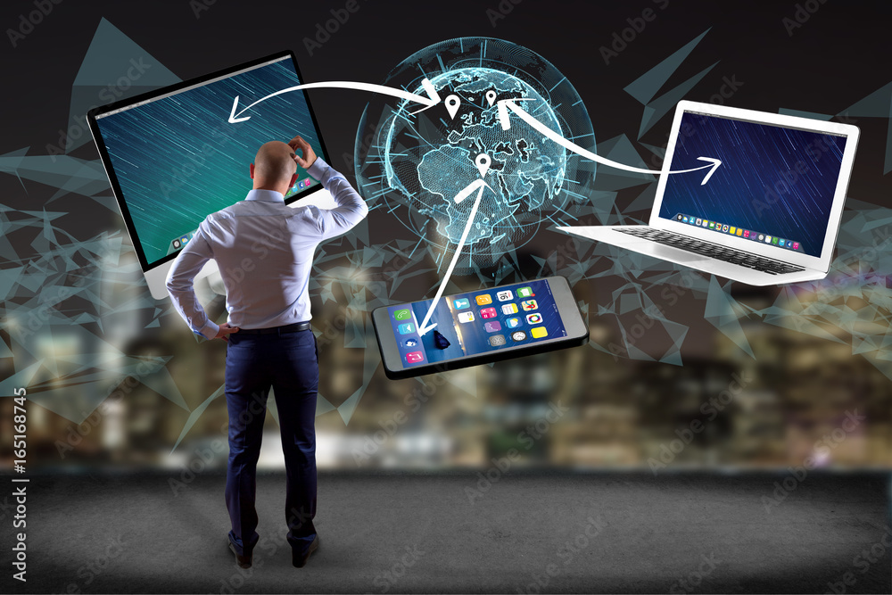 Poster businessman in front of a wall with computer and devices displayed on a futuristic interface with in