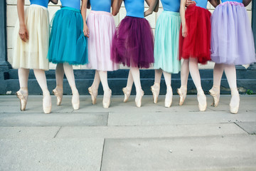 Ballet dancers dancing on street. Young ballerinas in color tutus. Ballet feet on the point