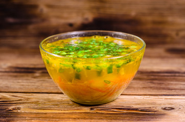 Vegetable soup in a glass bowl on wooden table