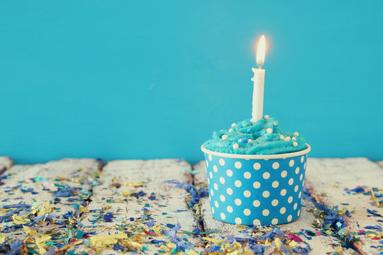 Birthday concept with cupcake and candle on wooden table