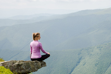 Fototapeta na wymiar Young woman sit on the top of mountains