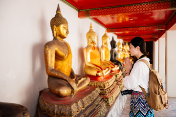 female student standing in front of buddha