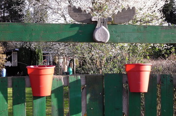 Gartenschmuck am Zaun eines Schrebergartens.