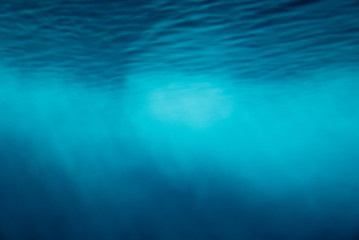 Underwater light ray beams background in blue tone.