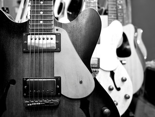 Many guitar shop in the store for sell in the market. Close up. For background. Front view.
