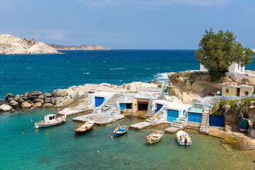 Traditional Greek fishing boats anchoring in Mandrakia village. Milos Island, Greece.