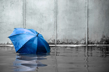 Blue umbrella floating concept. Flooded on street. .Waiting for help me after the rain. Black and...