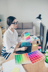 Close up side profile of busy young asian animation designer, drawing something on graphic tablet...
