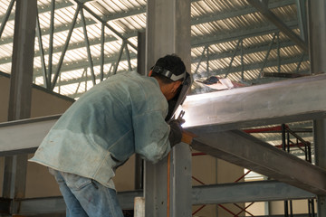 Man weld a metal with a welding machine.