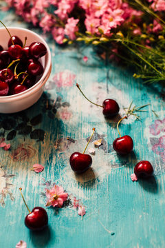 Cherries and flowers on the vintage table