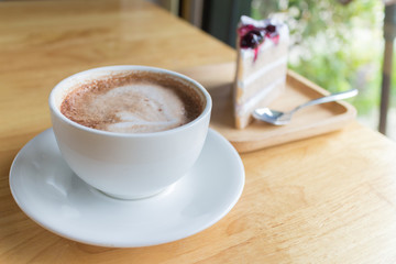 hot coffee mocha with foam milk and blueberry cake in countryside cafe