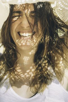 Happy smiling woman with a crochet scarf over her head.