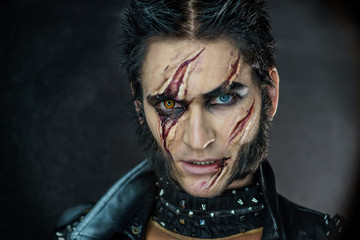 Professional make-up werewolf Wolverine with scars and orange eye