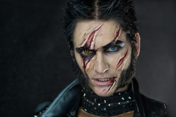 Professional make-up werewolf Wolverine with scars and orange eye
