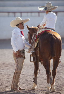 Mexican Guacho teaching boy to ride.