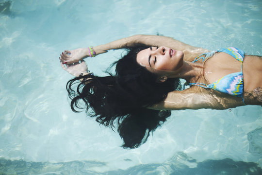 A beautiful young woman floating on the water