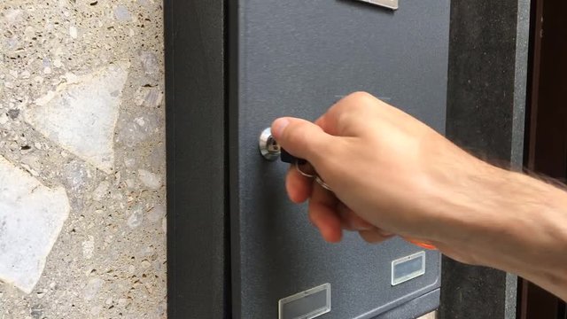 Uomo apre cassetta delle lettere piena