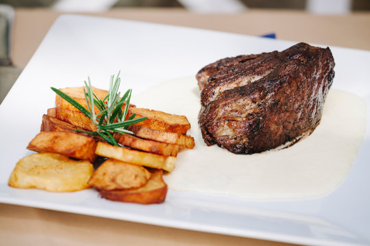Grilled strip steak with bearnaise sauce and potato wedges 