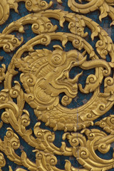 Fototapeta na wymiar Antique Thai traditional art wood carved pattern on temple door. 