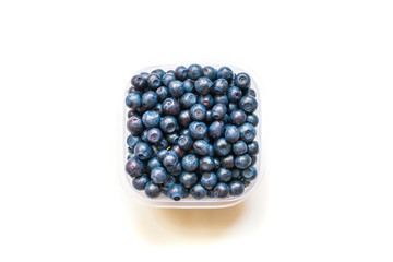Glass bowl with blueberries on white background top view