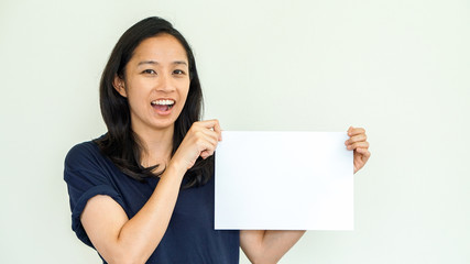 Casual Asian woman holding white sign with copy space
