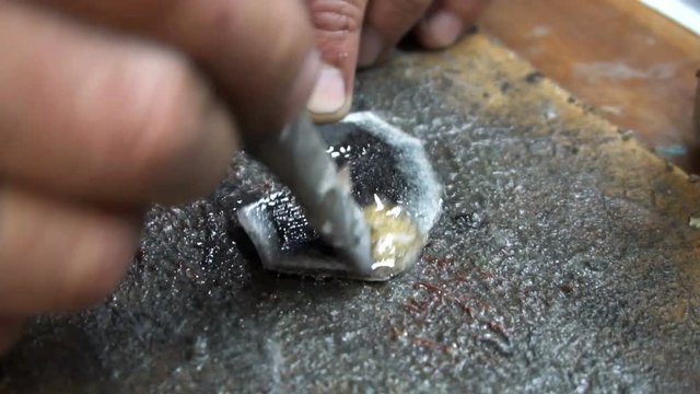 a shoemaker cleans a special knife black leather patch.
