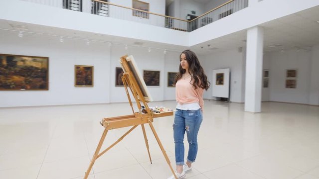 Picture gallery, girl standing in front of blank canvas.