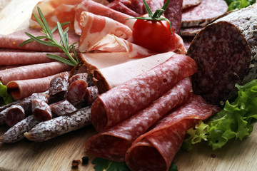 Food tray with delicious salami, pieces of sliced ham, sausage, tomatoes, salad and vegetable - Meat platter with selection