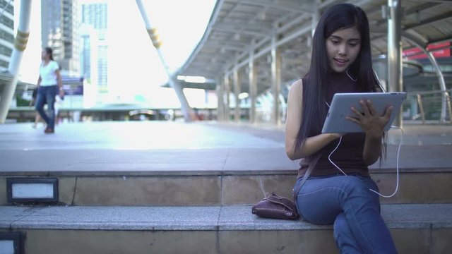 Woman using tablet touchscreen at Chong nonsi bridge, Bangkok City. She is a new generation with technology. Lifestye concept.