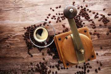 Coffee cup coffee mill and coffee beans on wooden table