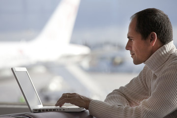 homme en hiver à l'aéroport avec un ordinateur portable