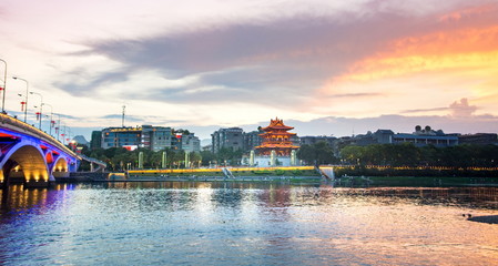 Fototapeta na wymiar Sunset over Li river with bridge and Xiaoyao tower view