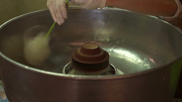 Process of making cotton candy close-up. Man making white cotton candy in cotton candy machine.