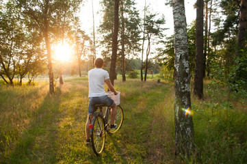 Obraz premium the guy on the bike in the Park, cyclist at sunset,