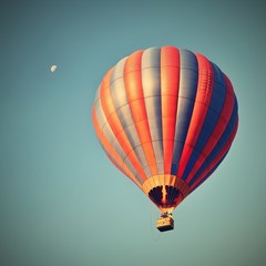 Fototapeta premium Colorful hot air balloon is flying at sunset. Natural colorful background with sky and moon.