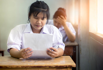 Fototapeta na wymiar Portrait of young girl students writing the exam with smile.