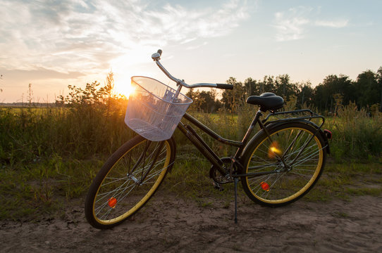 beautiful landscape image with Bicycle at sunset, classic bike with a basket