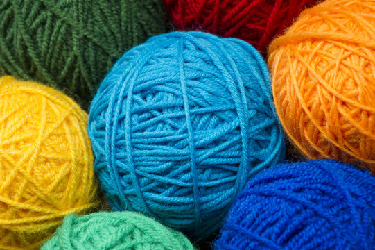 Woolen yarn balls, skeins of tangled colorful sewing threads, selective focus 