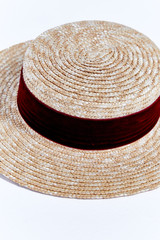 Fototapeta na wymiar Straw hat of light straw with velvet ribbon beautiful stylish fashion accessory for summer resort on white background in studio.
