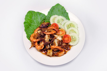Fried shrimp and squid with garlic and pepper in white plate on white background