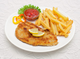 Zigeunerschnitzel mit Pommes frites -  Tellergericht auf weißem Tischtuch