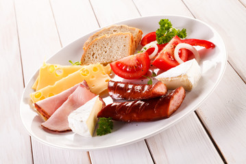 Breakfast - fried sausages, yellow cheese and vegetables 