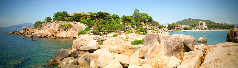 Rocky tropical coastline with blue ocean and clear sky