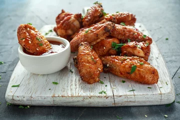 Foto op Canvas Baked chicken wings with sesame seeds and sweet chili sauce on white wooden board. © grinchh