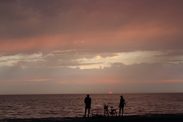 Fototapeta premium Girl and boy fishing on the sea at sunset 