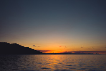 Fototapeta premium A bright, unforgettable sunset over the horizon line observed from the ship's deck