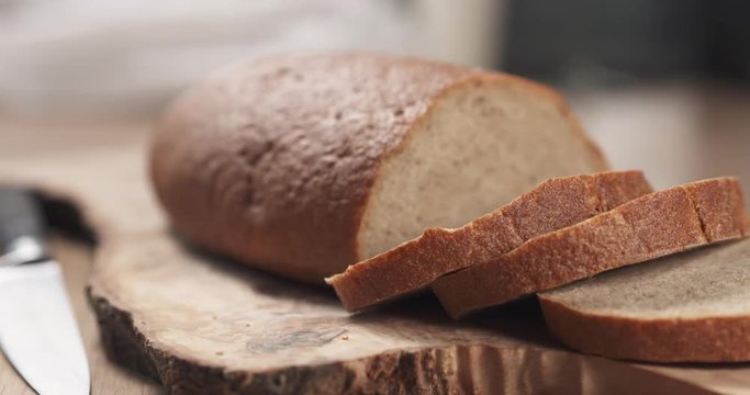 Side shot of slices of rye wheat rustic bread on cutting board