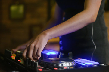 Hands disc jockey at the turntable. DJ plays on the best, famous CD players at nightclub during party. EDM, party concept.