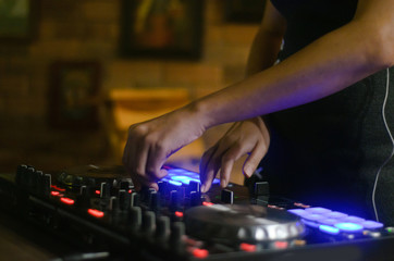 Hands disc jockey at the turntable. DJ plays on the best, famous CD players at nightclub during party. EDM, party concept.