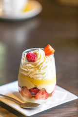 Sweet Dessert with strawberries, white cream, lemon on glass